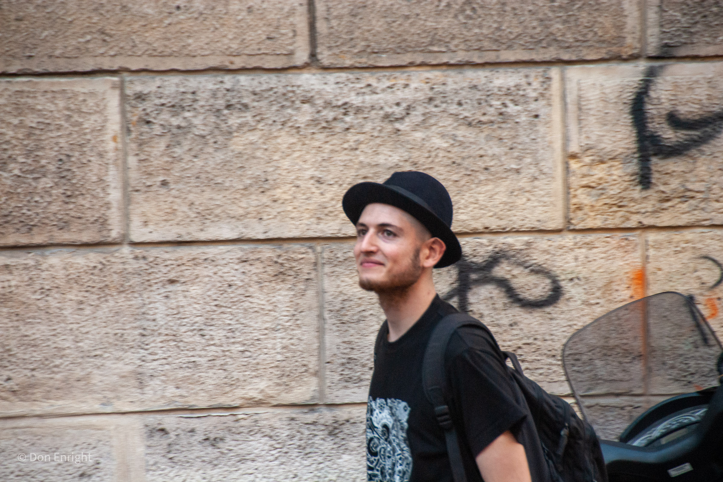 Young man smiling walking down the street.