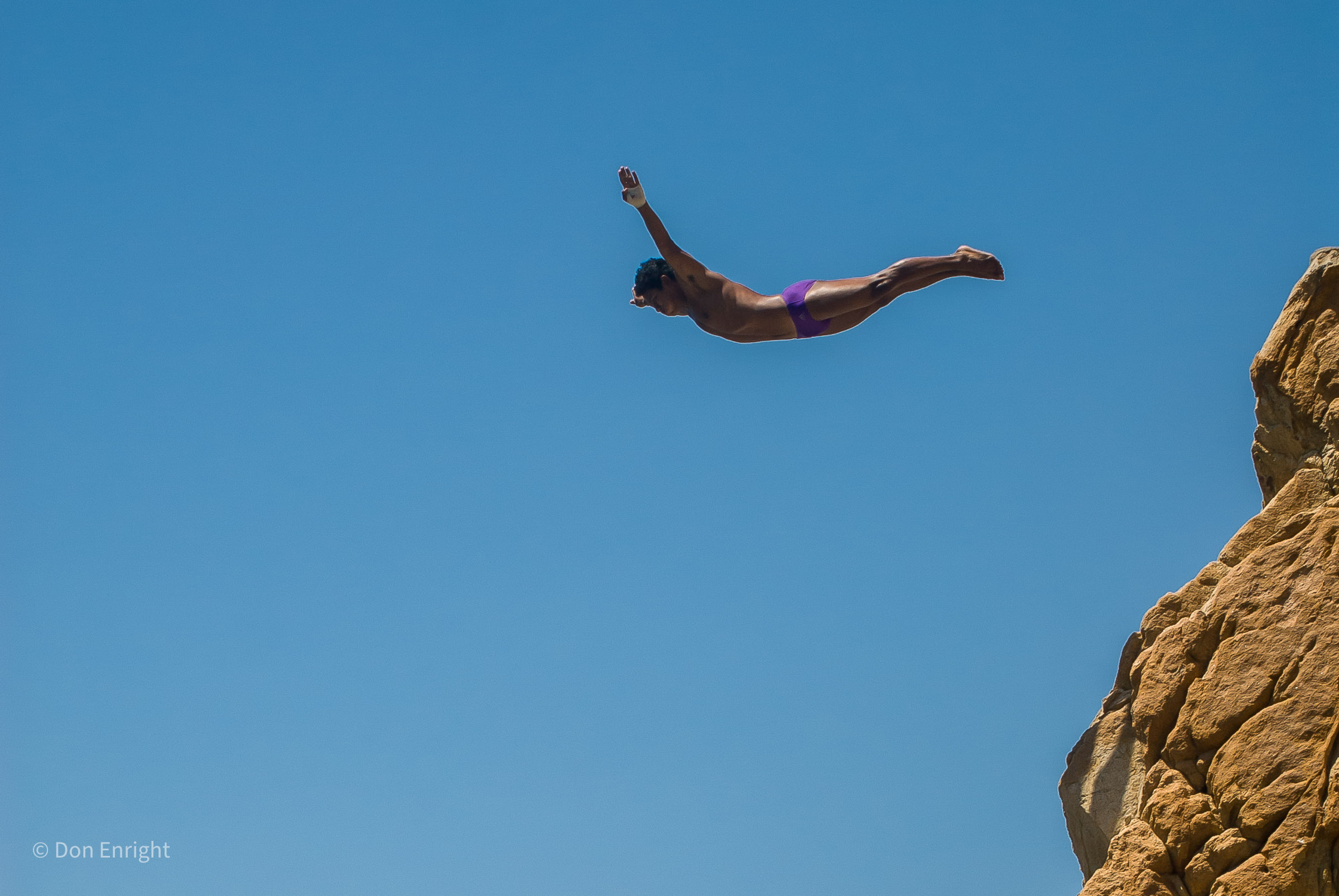 man diving off a cliff